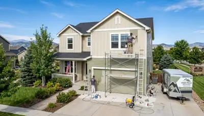 Professional house painters working on exterior home in Loveland CO
